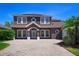 Two-story home boasts well-manicured landscaping, brick driveway, and a welcoming front entrance with white trim at 7299 Vista Park Blvd, Orlando, FL 32829