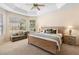Bright main bedroom featuring tray ceiling, neutral carpet, large windows, and contemporary furnishings at 7299 Vista Park Blvd, Orlando, FL 32829