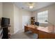 Home office features ceiling fan, large desk, a large window for natural light and built-in shelves at 7299 Vista Park Blvd, Orlando, FL 32829