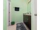 The bathroom features a shower, a sink and green walls at 9731 Pepper Tree Trl, Wildwood, FL 34785