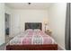 Well-lit bedroom featuring a comfortable bed, side table with a lamp, and easy access to the hallway at 9731 Pepper Tree Trl, Wildwood, FL 34785