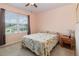 This bedroom has pink walls and a window that lets in natural light at 9731 Pepper Tree Trl, Wildwood, FL 34785