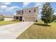 Charming home features a two-car garage, manicured lawn, and mature landscaping adding to its curb appeal at 9731 Pepper Tree Trl, Wildwood, FL 34785