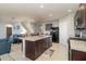 Open kitchen with a center island, dark wood cabinets, stainless steel appliances, and seamless connection to the living area at 9731 Pepper Tree Trl, Wildwood, FL 34785