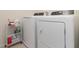 Bright laundry area features a modern washer and dryer set, complete with helpful storage cart at 9731 Pepper Tree Trl, Wildwood, FL 34785