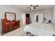 Large main bedroom with soft carpet, dresser, TV, ceiling fan, and walk-in closets offer comfort at 9731 Pepper Tree Trl, Wildwood, FL 34785