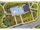 Overhead view of the community pool, amenity center, playground, landscaping, and parking at 1025 Augustus Dr, Davenport, FL 33896