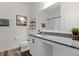 Modern bathroom featuring granite countertop, white vanity, and decorative mountain art on the wall at 1025 Augustus Dr, Davenport, FL 33896