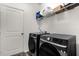 Contemporary laundry room includes modern appliances, a storage shelf, and a convenient door leading to other areas of the home at 1025 Augustus Dr, Davenport, FL 33896