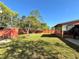 A lush backyard with green lawn, sunroom addition, and storage shed at 1062 Stillwater Ave, Deltona, FL 32725