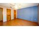 Bright bedroom featuring wood floors, a ceiling fan, and two wood paneled doors at 1062 Stillwater Ave, Deltona, FL 32725