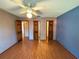 Bedroom with wood floor and ceiling fan, featuring two wood doors and one open door at 1062 Stillwater Ave, Deltona, FL 32725