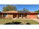 Inviting brick home featuring a matching colored garage door, solar panels, and flower beds at 1062 Stillwater Ave, Deltona, FL 32725