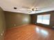 Spacious living room featuring laminate wood flooring, ceiling fan, and natural light from a large window at 1062 Stillwater Ave, Deltona, FL 32725