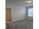 Bright bedroom with plush gray carpet, a window, and a door leading to another room at 11151 Rising Sun St, Orlando, FL 32829