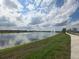 Scenic community pond with fountains, a sidewalk, and lush green grass at 11151 Rising Sun St, Orlando, FL 32829