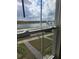 Window view overlooking the community lake, green lawn, and sidewalks under a partly cloudy sky at 11151 Rising Sun St, Orlando, FL 32829