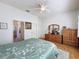 Well-lit bedroom featuring matching wooden furniture, a ceiling fan, and an ensuite bathroom at 120 Crepe Myrtle Dr, Groveland, FL 34736