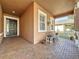 Inviting front porch featuring brick flooring, a stylish front door, and comfortable seating with decorative plants at 120 Crepe Myrtle Dr, Groveland, FL 34736