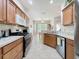 Well-lit kitchen featuring wooden cabinets, modern stainless steel appliances, and a view of the dining area at 120 Crepe Myrtle Dr, Groveland, FL 34736