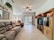 Open living room with a built-in entertainment center, tile flooring, and sliding glass doors to the lanai at 120 Crepe Myrtle Dr, Groveland, FL 34736