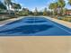 Aerial view of blue tennis court with palm trees in the background at 120 Crepe Myrtle Dr, Groveland, FL 34736