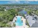 Aerial view of the community pool, clubhouse, and surrounding neighborhood with pond at 14209 Lake Live Oak Dr, Orlando, FL 32828