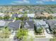 Aerial view of a residential neighborhood showcasing well-maintained homes, mature trees, and blue sky at 14209 Lake Live Oak Dr, Orlando, FL 32828