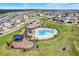 An aerial shot showcasing a community pool, splash pad, playground, and parking for residents and guests at 14315 Crestavista Ave, Clermont, FL 34714