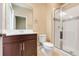 Bright bathroom featuring a shower with glass doors, toilet, and a vanity with a solid surface counter at 14315 Crestavista Ave, Clermont, FL 34714