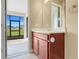 Bathroom vanity with modern cabinet, mirror, and backyard views through the sliding glass door at 14315 Crestavista Ave, Clermont, FL 34714