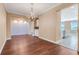 Open-concept dining area with wood floors, decorative accent wall, and kitchen view at 14315 Crestavista Ave, Clermont, FL 34714