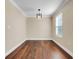 A dining room featuring wood floors, a modern light fixture and neutral walls at 14315 Crestavista Ave, Clermont, FL 34714