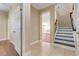 Inviting foyer featuring tile flooring, staircase with white risers, and an open doorway to other rooms at 14315 Crestavista Ave, Clermont, FL 34714