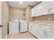 Laundry room with modern washer, dryer, and built in shelving and cabinets at 14315 Crestavista Ave, Clermont, FL 34714