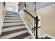 Staircase featuring white risers, black treads, and a wrought iron railing at 14315 Crestavista Ave, Clermont, FL 34714