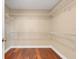 Walk-in closet featuring built-in shelving and wood flooring at 14315 Crestavista Ave, Clermont, FL 34714