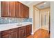 Wet bar with dark wood cabinets, quartz countertops, and tile backsplash at 14315 Crestavista Ave, Clermont, FL 34714