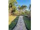 Landscaped backyard featuring a stone pathway leading to a black metal fence at 14339 Windchime Ln, Orlando, FL 32837