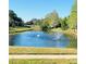 Community pond with beautiful water fountain features, surrounded by trees and green space at 14339 Windchime Ln, Orlando, FL 32837