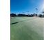 Outdoor tennis court with well-maintained surface, net and clear sky at 14339 Windchime Ln, Orlando, FL 32837