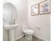 Bathroom featuring white pedestal sink, decorative mirror, and modern toilet at 14418 Bayuk Way, Winter Garden, FL 34787