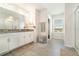 Bathroom with double vanity, granite countertops, and tiled floors; glass shower, and natural light at 14418 Bayuk Way, Winter Garden, FL 34787