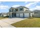 The two-story home has a wide driveway leading to a spacious three-car garage at 14418 Bayuk Way, Winter Garden, FL 34787