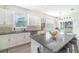 Bright kitchen showcasing a granite island with bar stools, a wine rack and tiled backsplash at 14418 Bayuk Way, Winter Garden, FL 34787