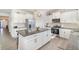 Well-lit kitchen features granite island with bar stools, stainless steel appliances, and white cabinetry at 14418 Bayuk Way, Winter Garden, FL 34787