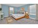 Bedroom with blue walls featuring a queen sized bed, side tables and soft rug at 1555 Flange Dr, Davenport, FL 33896