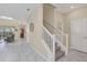 Inviting foyer with staircase, neutral tones, and marble-look tile flooring at 1555 Flange Dr, Davenport, FL 33896