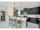 Bright eat-in kitchen featuring a center island, dark cabinets and unique lighting fixtures at 1555 Flange Dr, Davenport, FL 33896