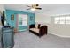 Loft area featuring a teal accent wall, comfortable seating, and a ceiling fan at 1555 Flange Dr, Davenport, FL 33896